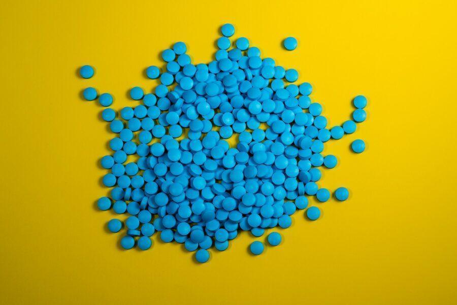 a pile of blue pills on a yellow background
